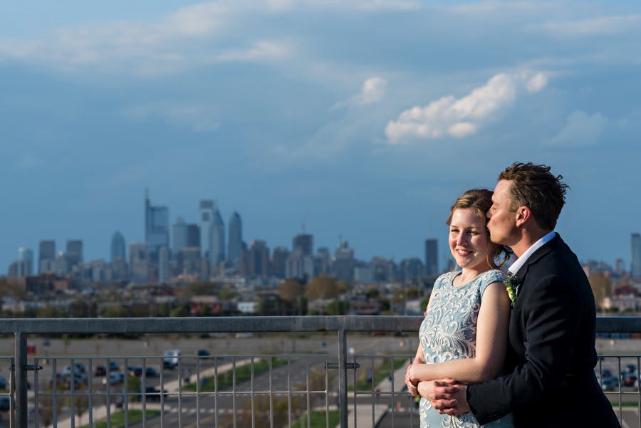 A wedding couple hold each other at Citizens Bank Park with a view of the Philly Skyline behind them.